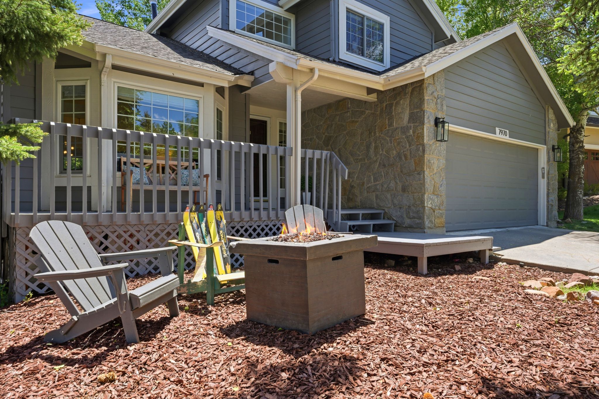 Stone veneer exterior with complementary siding, a two-car garage, and a bay window