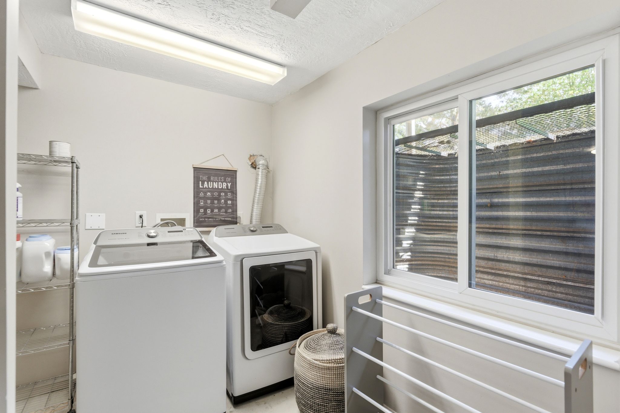 Dedicated laundry area featuring a white top-load washer and front-load dryer