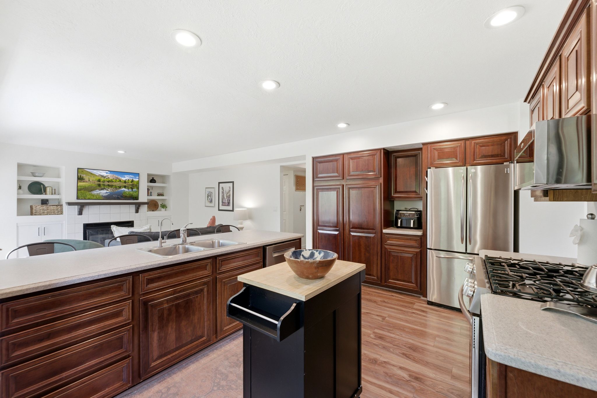 Kitchen featuring LVP flooring, recessed lighting, and rich wood cabinetry