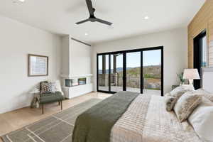 Spacious room featuring light wood-finish flooring, a built-in corner fireplace, and a ceiling fan