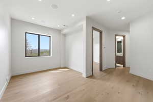 Light wood-finish flooring with white baseboards and walls
