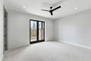 Double door exterior access, recessed lighting, ceiling fan, neutral wall color, and light-toned carpet flooring