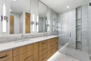 Double vanity featuring light wood cabinetry with brushed nickel hardware and integrated sinks