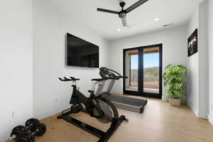 Versatile bonus room featuring light wood-finish flooring, a wall-mounted display, recessed lighting, and a modern ceiling fan