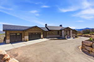 Modern mountain-style residence featuring a dark asphalt shingle roof, wood-finish siding, and stone accents