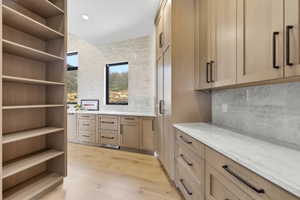 Wood-finish cabinetry and built-in shelving with matte black hardware