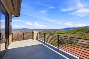 Expansive outdoor balcony featuring large format tile flooring and a modern horizontal bar railing system