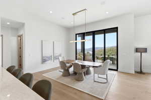 Dining area featuring expansive glass sliding doors, recessed lighting, and wood-finish flooring