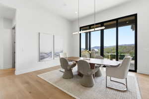 Spacious room with light wood-finish flooring and a minimalist chandelier