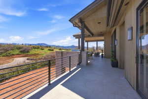Expansive covered patio featuring large format tile flooring, a horizontal bar railing, and wood-paneled ceilings