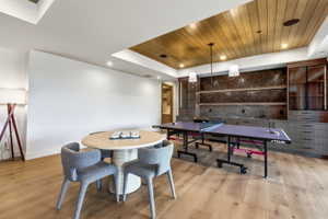 Spacious room featuring wood-finish flooring and a wood-paneled ceiling accent