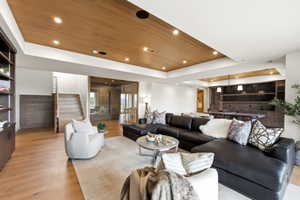 Spacious open-concept living area featuring wood-finish flooring and a wood-paneled ceiling