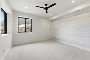 Bedroom featuring a textured accent wall, recessed lighting, and a modern ceiling fan
