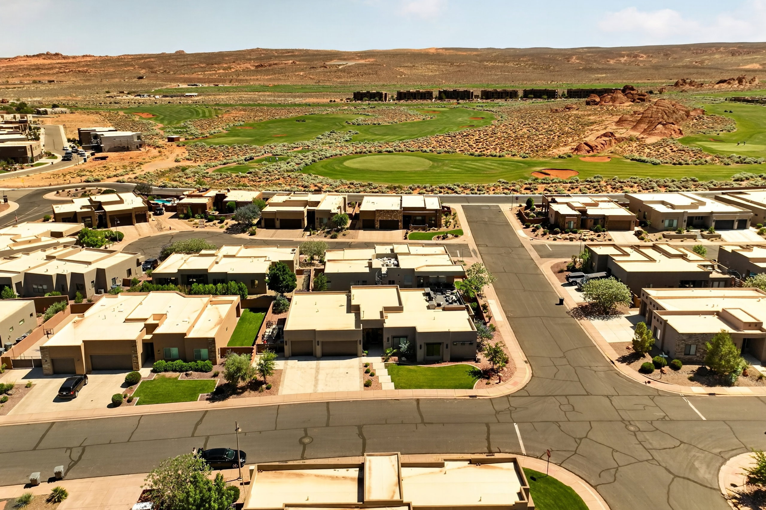 Desert landscape community featuring single-story residences, paved streets, and a golf course
