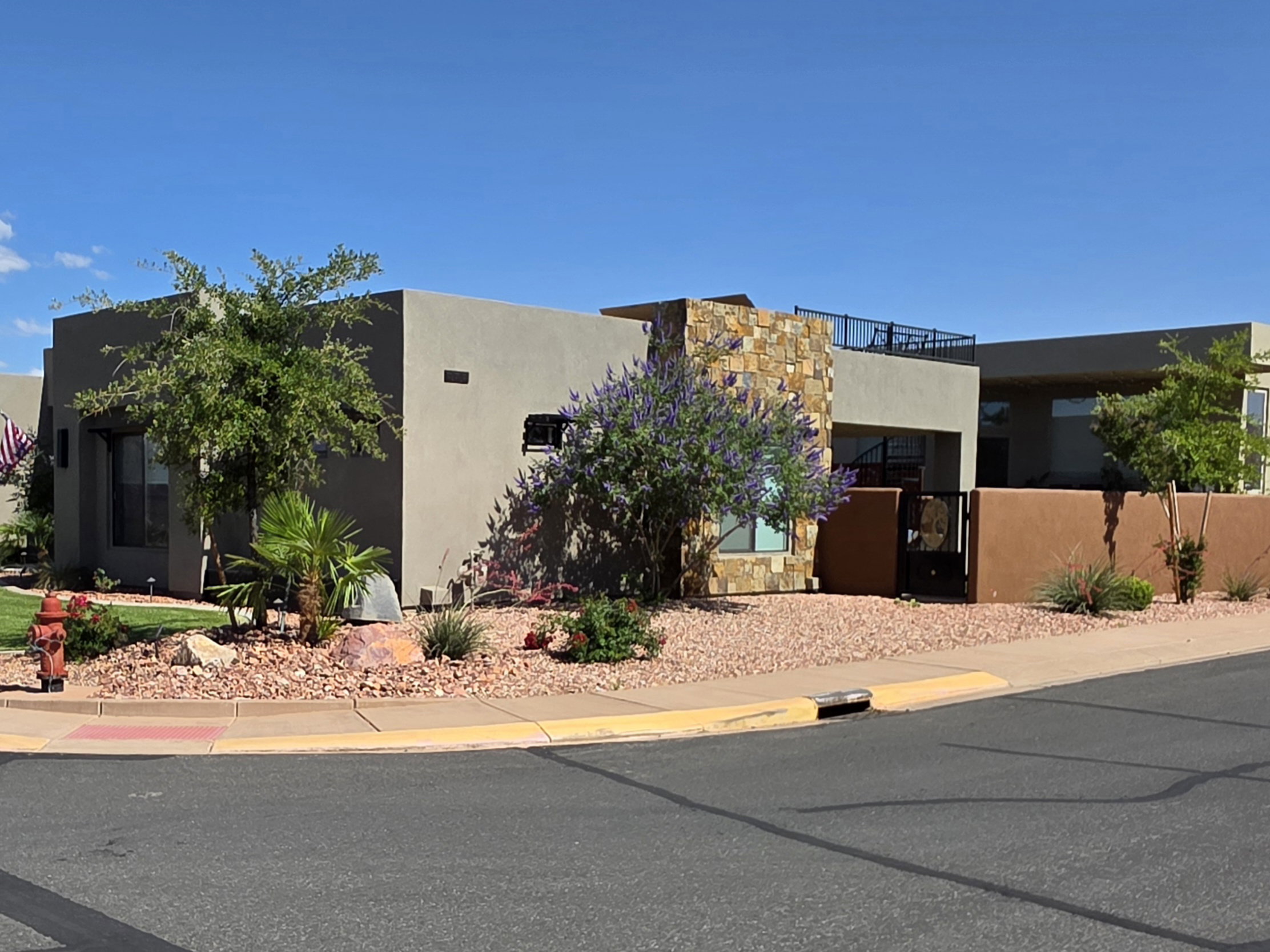 Modern desert-style residence with a stucco exterior, stone facade accents, and a flat roofline