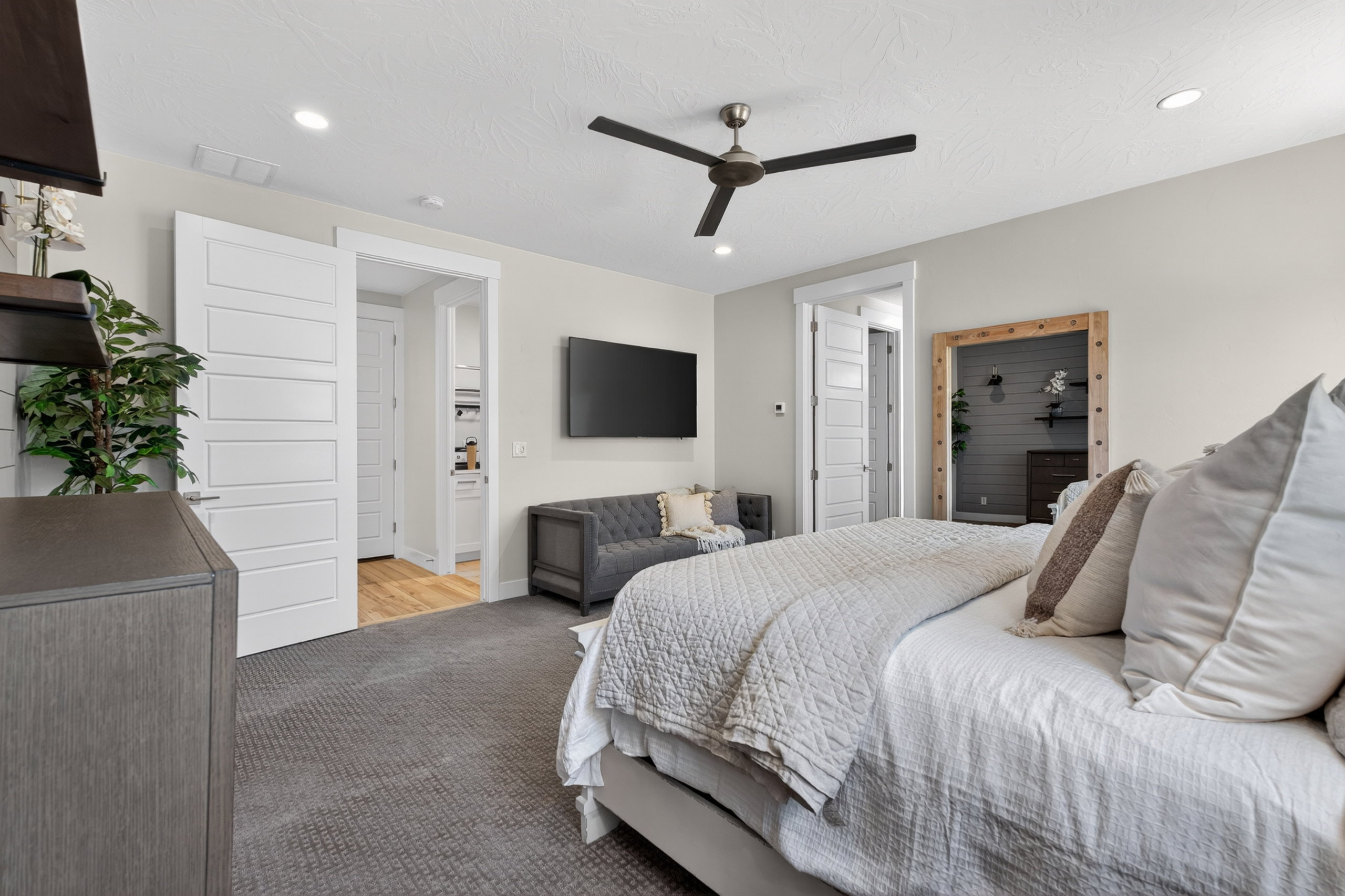Spacious room featuring neutral carpeting, a contemporary ceiling fan, recessed lighting, and modern paneled doors