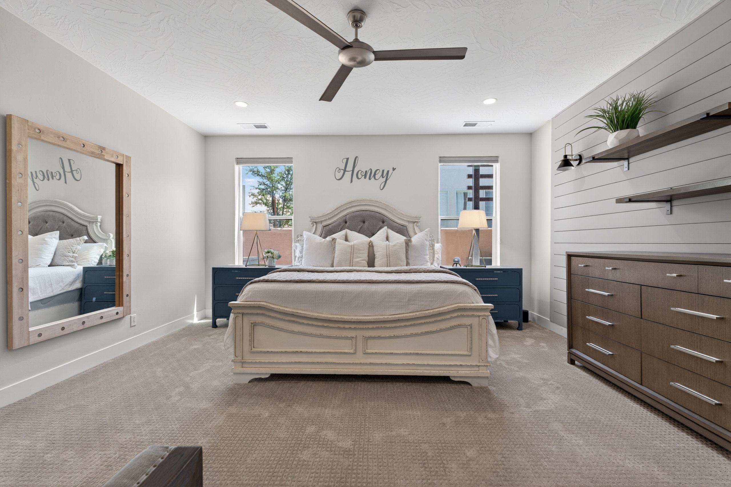 Carpeted bedroom featuring a ceiling fan with integrated lighting, recessed lighting, and dual windows