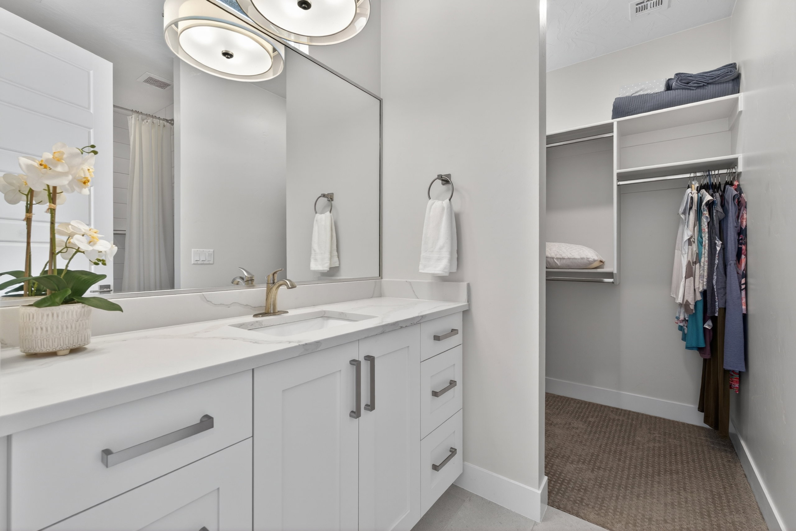 Bathroom vanity featuring a single integrated sink, brass-finish faucet, and white countertop