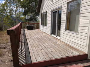 Expansive wood deck with a red painted railing, offering direct access to the interior via a sliding glass door