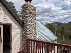 Stone veneer chimney on a structure with horizontal siding and a metal roof
