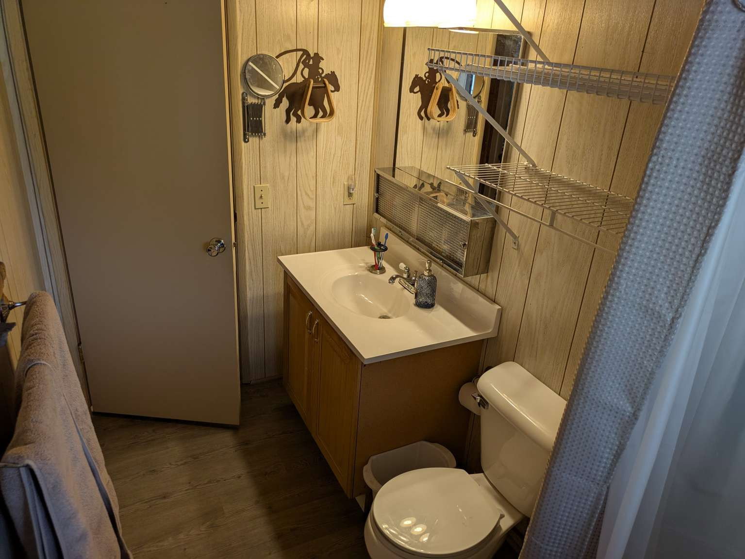 Bathroom vanity featuring an integrated sink with chrome faucet, wood-finish cabinetry, and a mirrored medicine cabinet