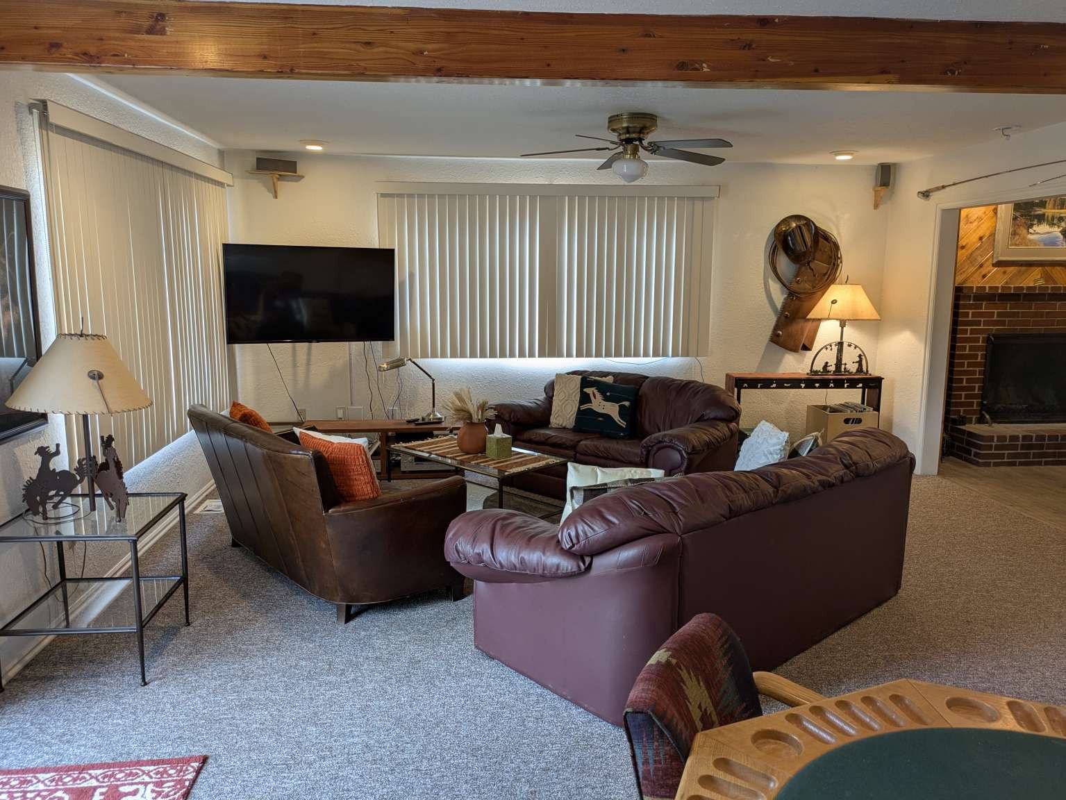 Living area featuring exposed wood ceiling beams and wall-to-wall carpeting