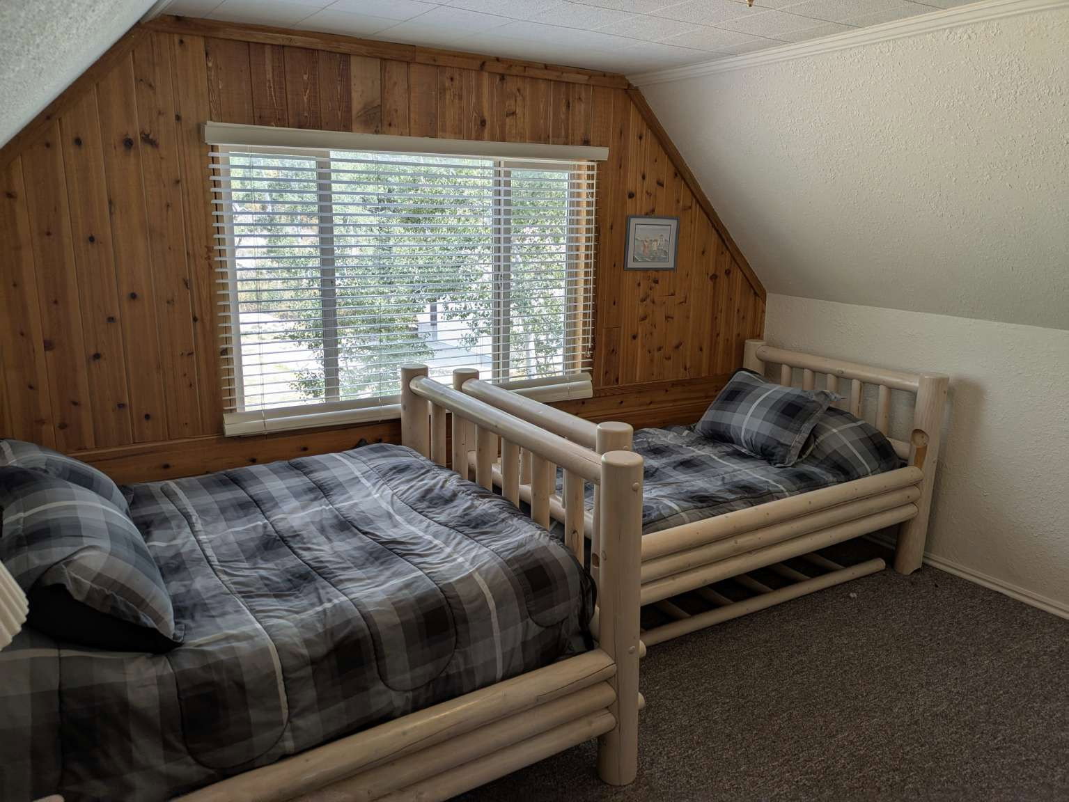 Wood-paneled accent wall with a window featuring horizontal blinds