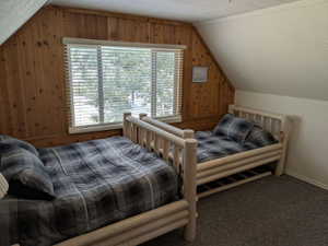 Wood-paneled accent wall with a window featuring horizontal blinds