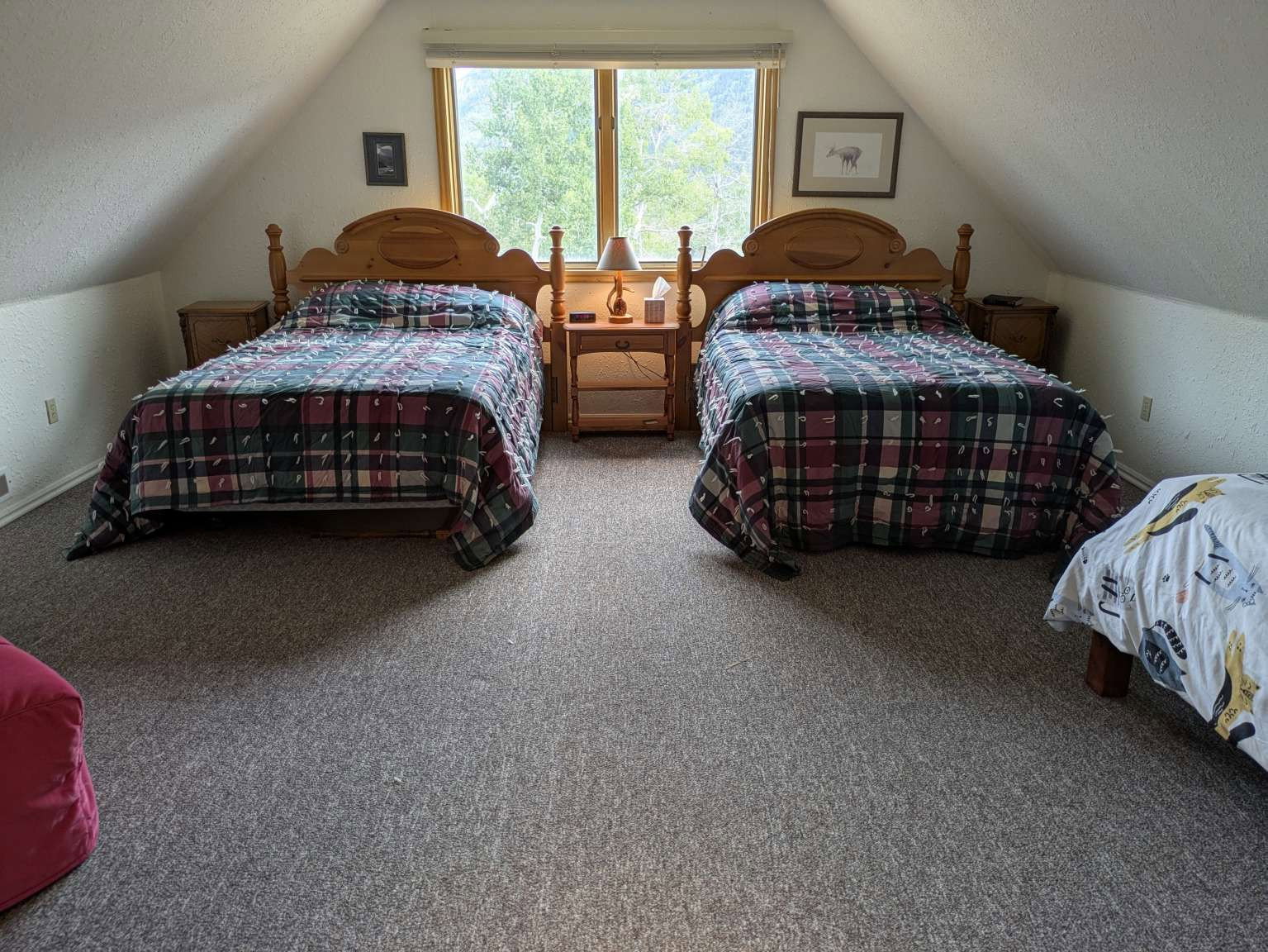 Spacious bedroom featuring sloped ceilings, a large window, and light gray carpet flooring