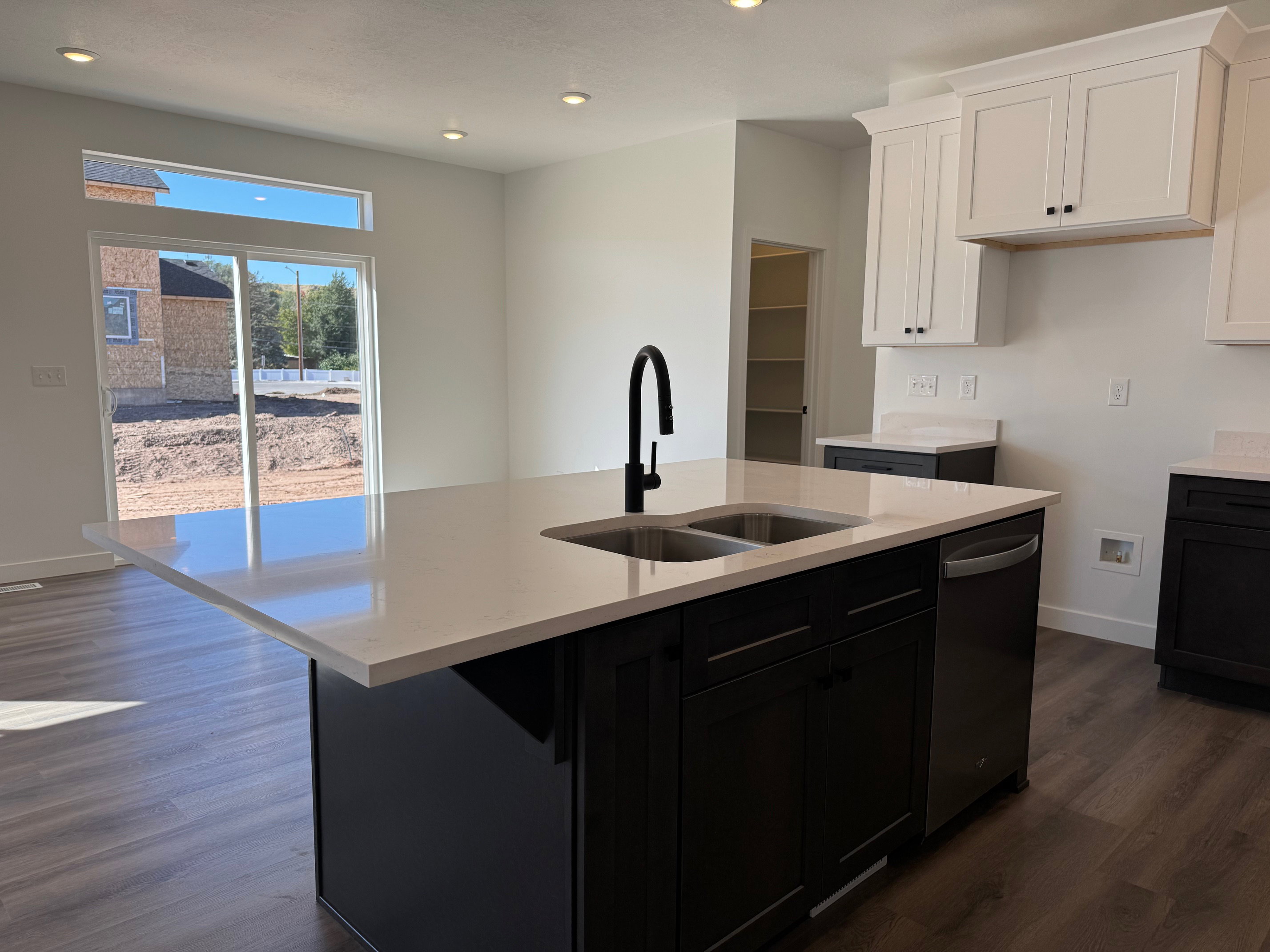 Kitchen island featuring a double-basin undermount sink with a matte black gooseneck faucet