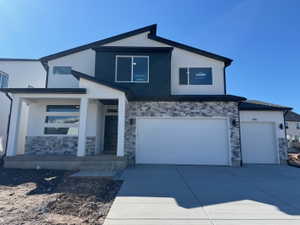Contemporary facade featuring white stucco, dark siding, and stacked stone accents