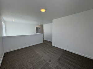 Spacious carpeted landing featuring recessed lighting, a white painted half-wall, and a bright, neutral color palette