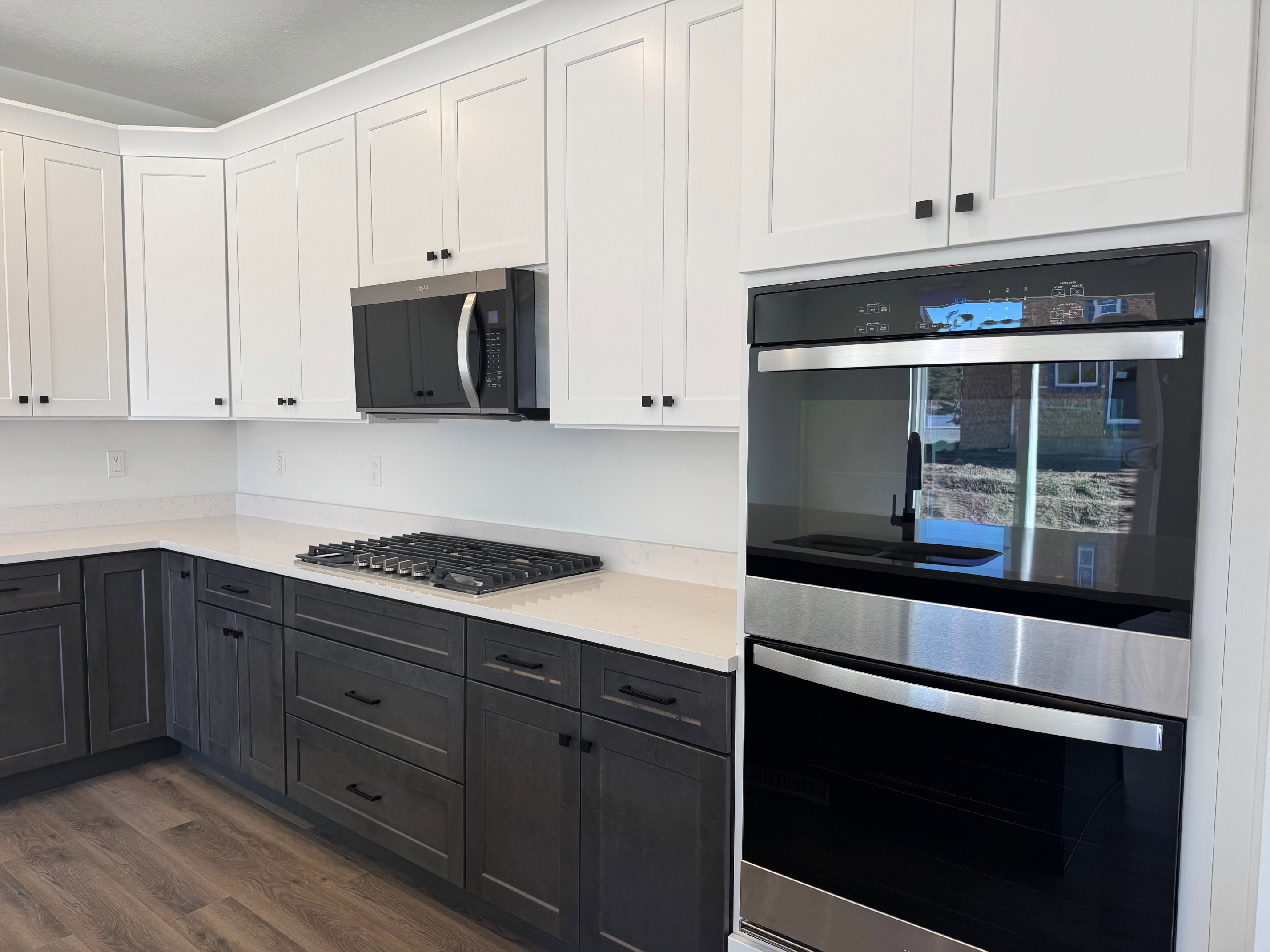 Modern kitchen featuring two-tone cabinetry with white upper and dark lower units