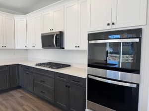 Modern kitchen featuring two-tone cabinetry with white upper and dark lower units