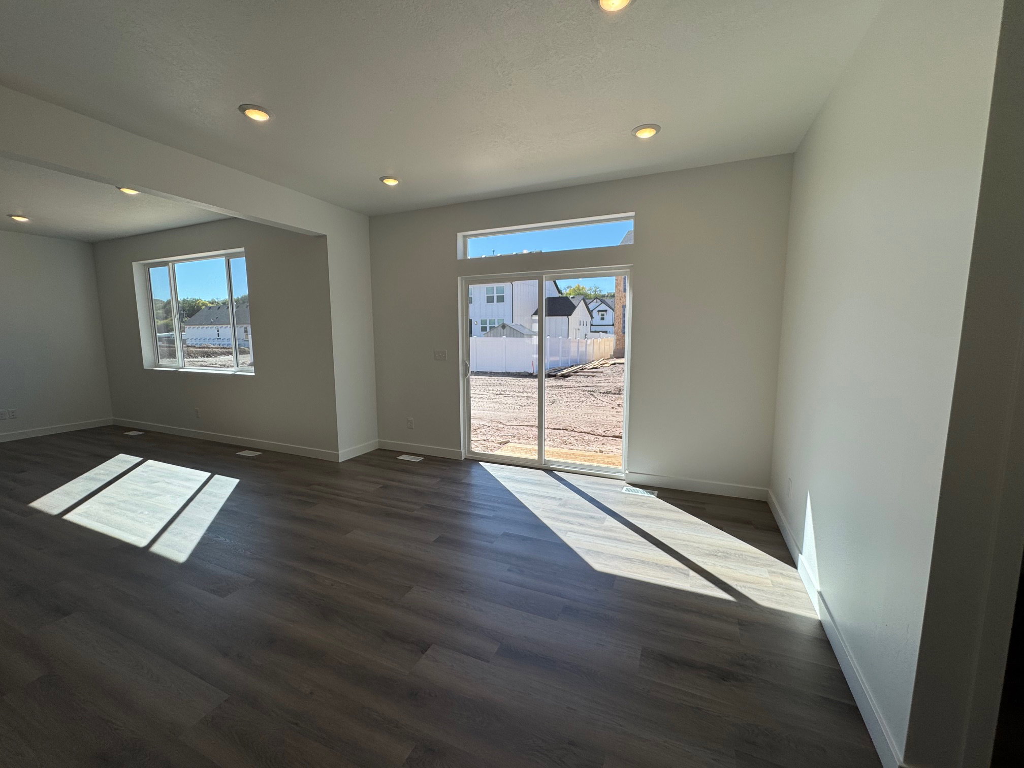 Spacious interior featuring wood-finish flooring, recessed lighting, and white baseboards