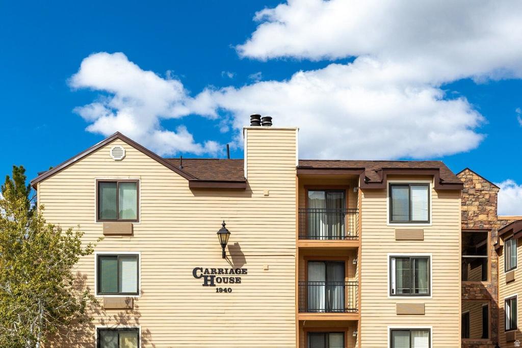 Multi-level building with light tan siding and brown trim