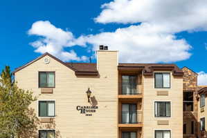 Multi-level building with light tan siding and brown trim