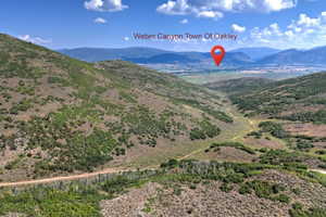 Expansive mountain terrain with varied vegetation and a distant valley