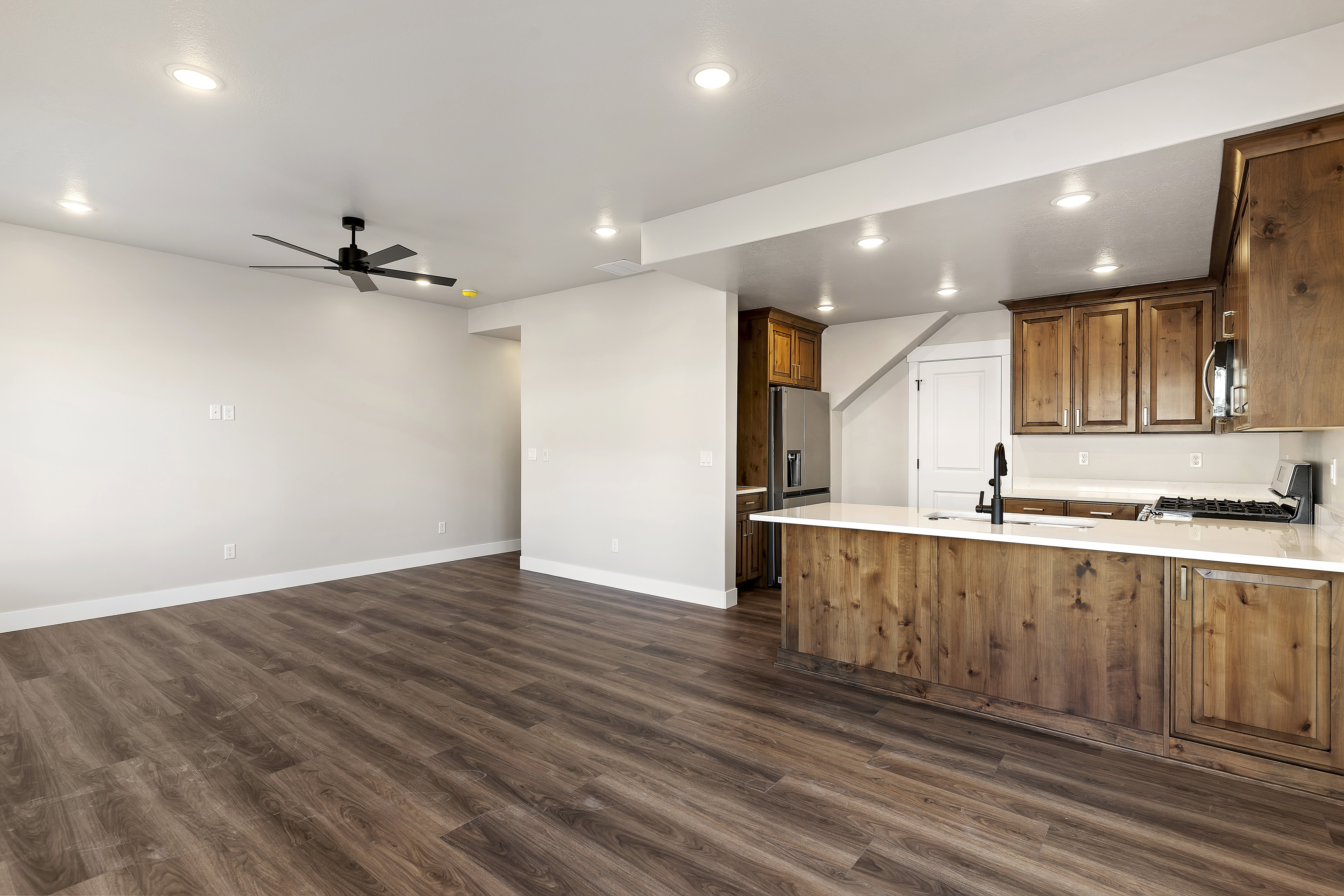 Open-concept living space featuring wood-finish flooring, recessed lighting, and a contemporary ceiling fan