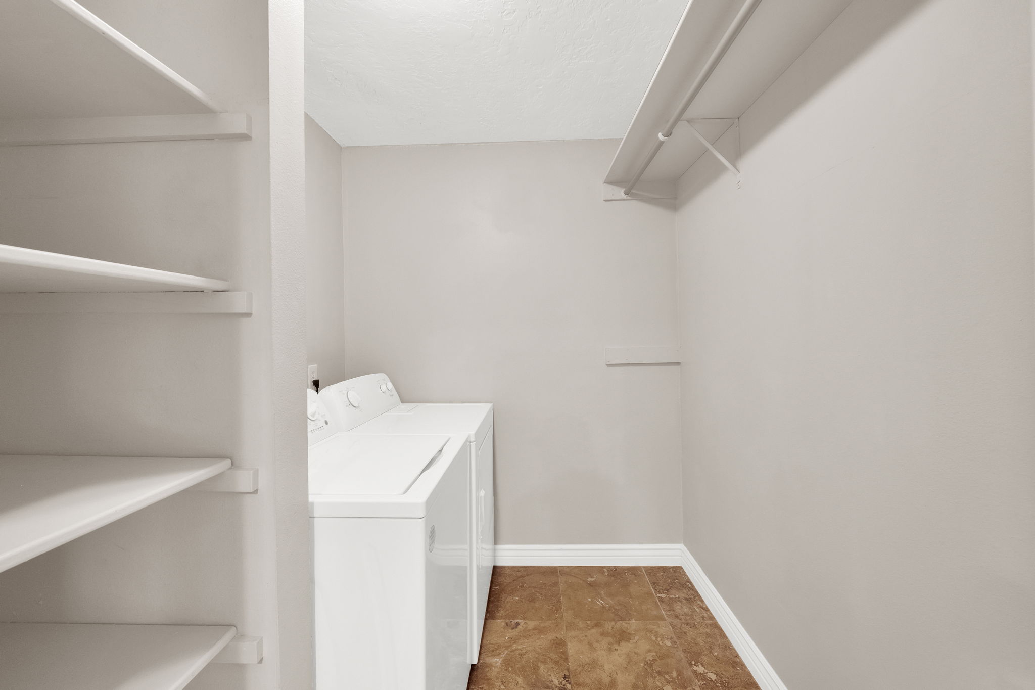 Dedicated laundry space featuring a white top-load washer and dryer set