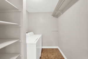 Dedicated laundry space featuring a white top-load washer and dryer set