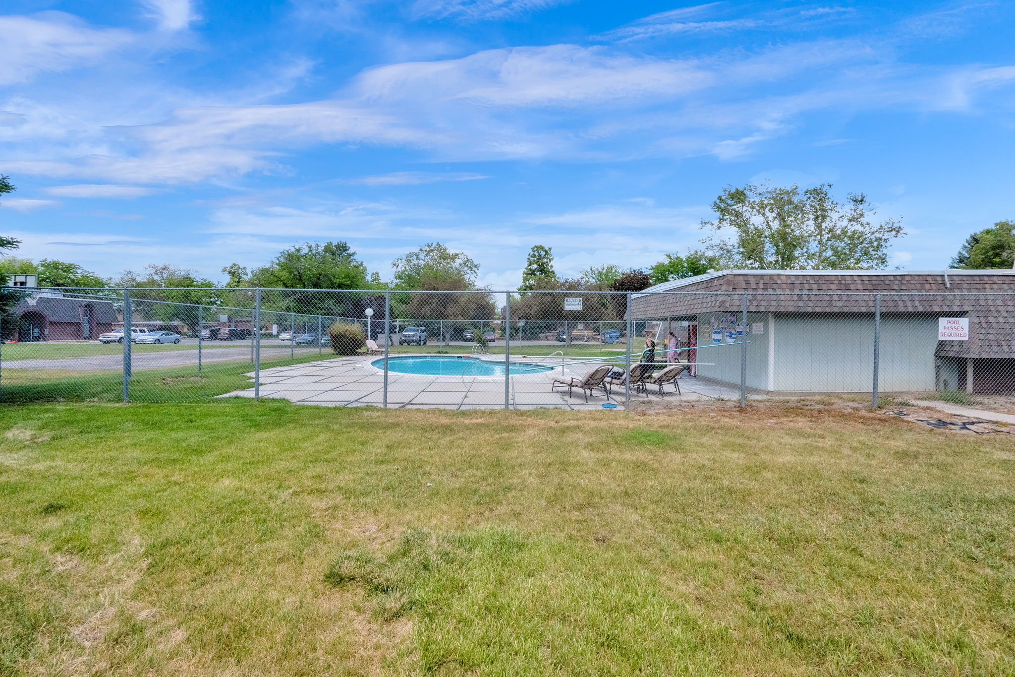 Outdoor swimming pool area featuring a concrete deck and privacy fencing