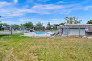 Outdoor swimming pool area featuring a concrete deck and privacy fencing
