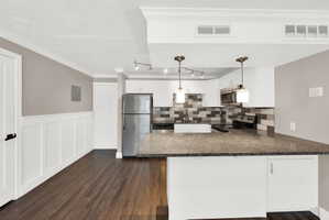 Kitchen featuring granite countertops, stainless steel appliances, and a mosaic tile backsplash