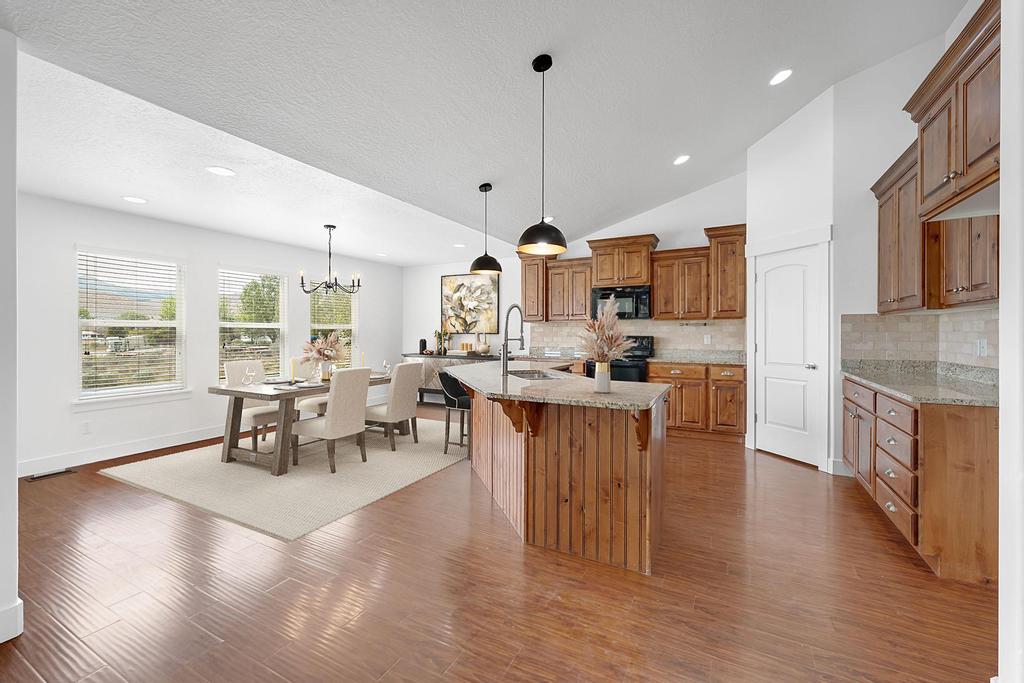 Spacious kitchen featuring warm wood cabinetry, granite countertops, and a large center island