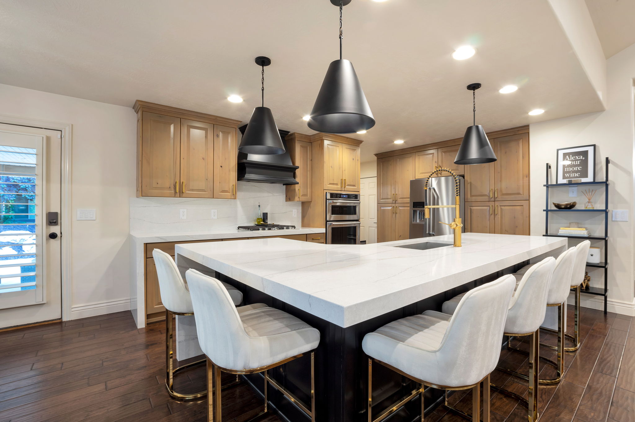 Gourmet kitchen centered around an oversized waterfall island with seating for family and guests.