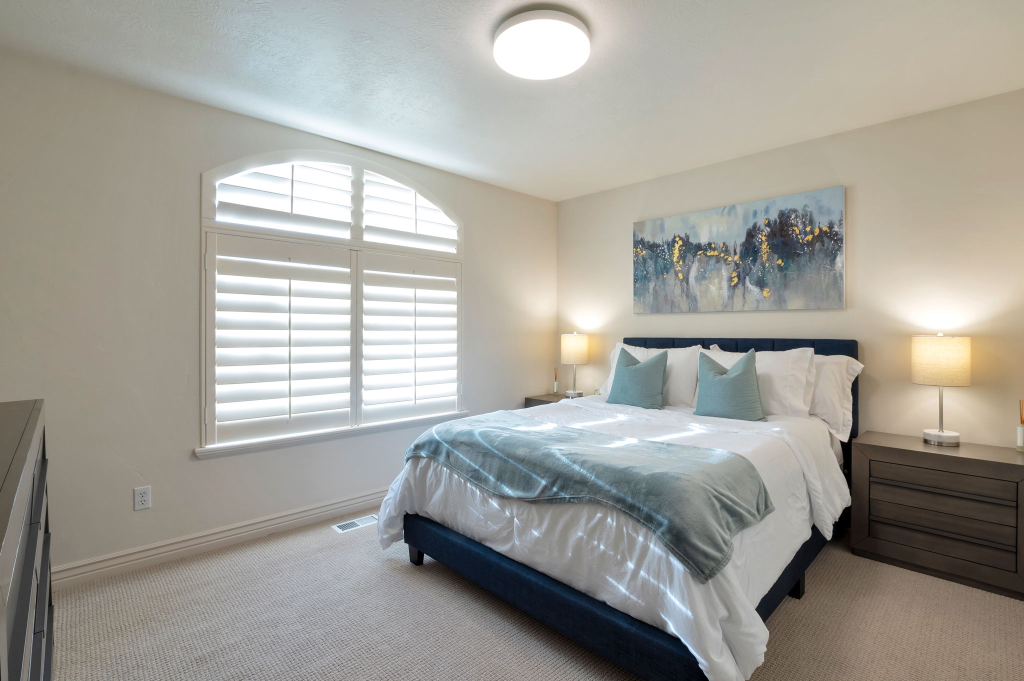 Generously sized secondary bedroom featuring plantation shutters and abundant natural light.