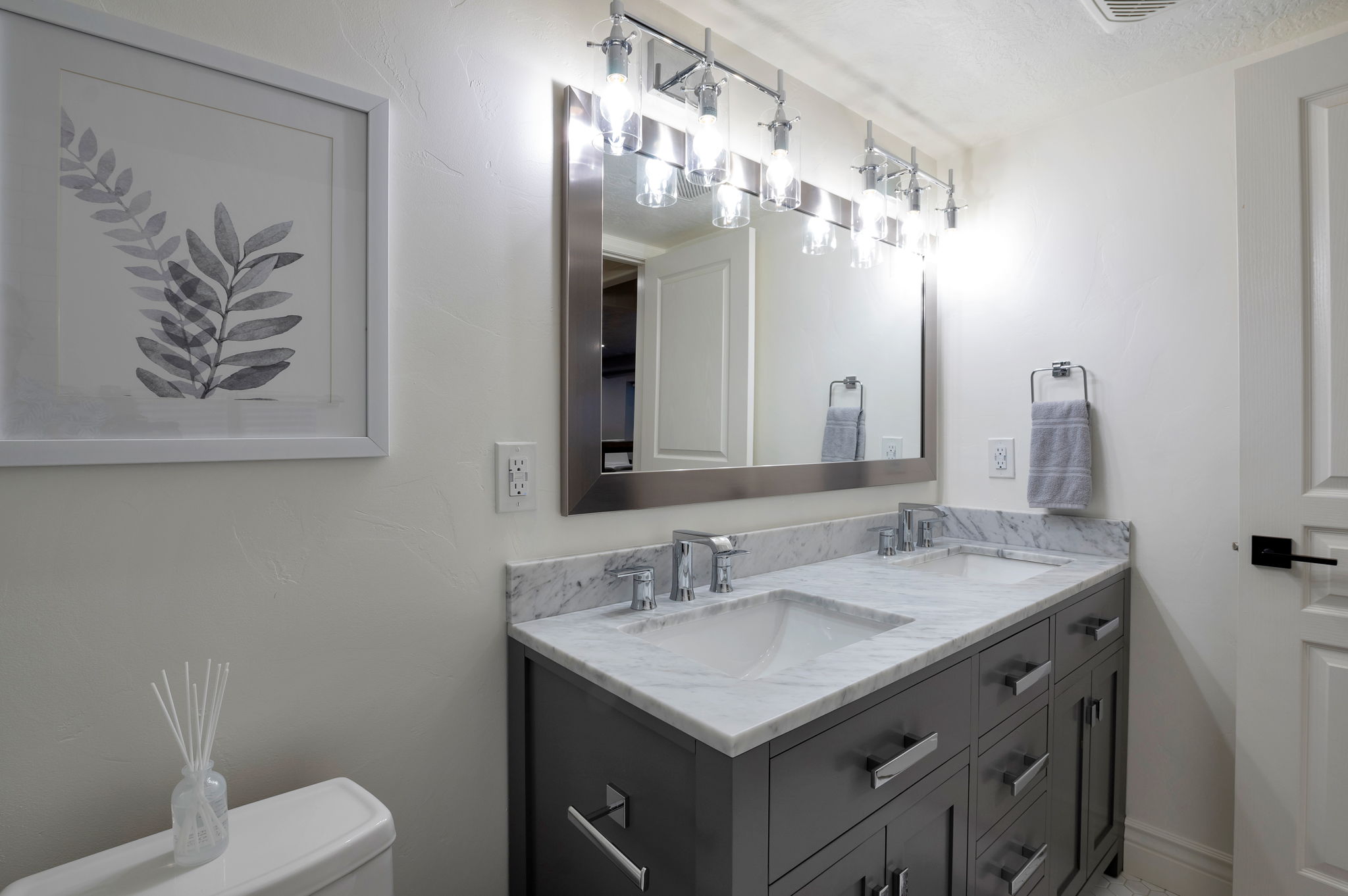 Updated full bath with dual sinks and stone countertops.