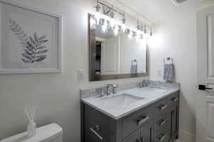 Dual undermount sinks set into a marble-finish countertop with a dark gray vanity featuring chrome hardware