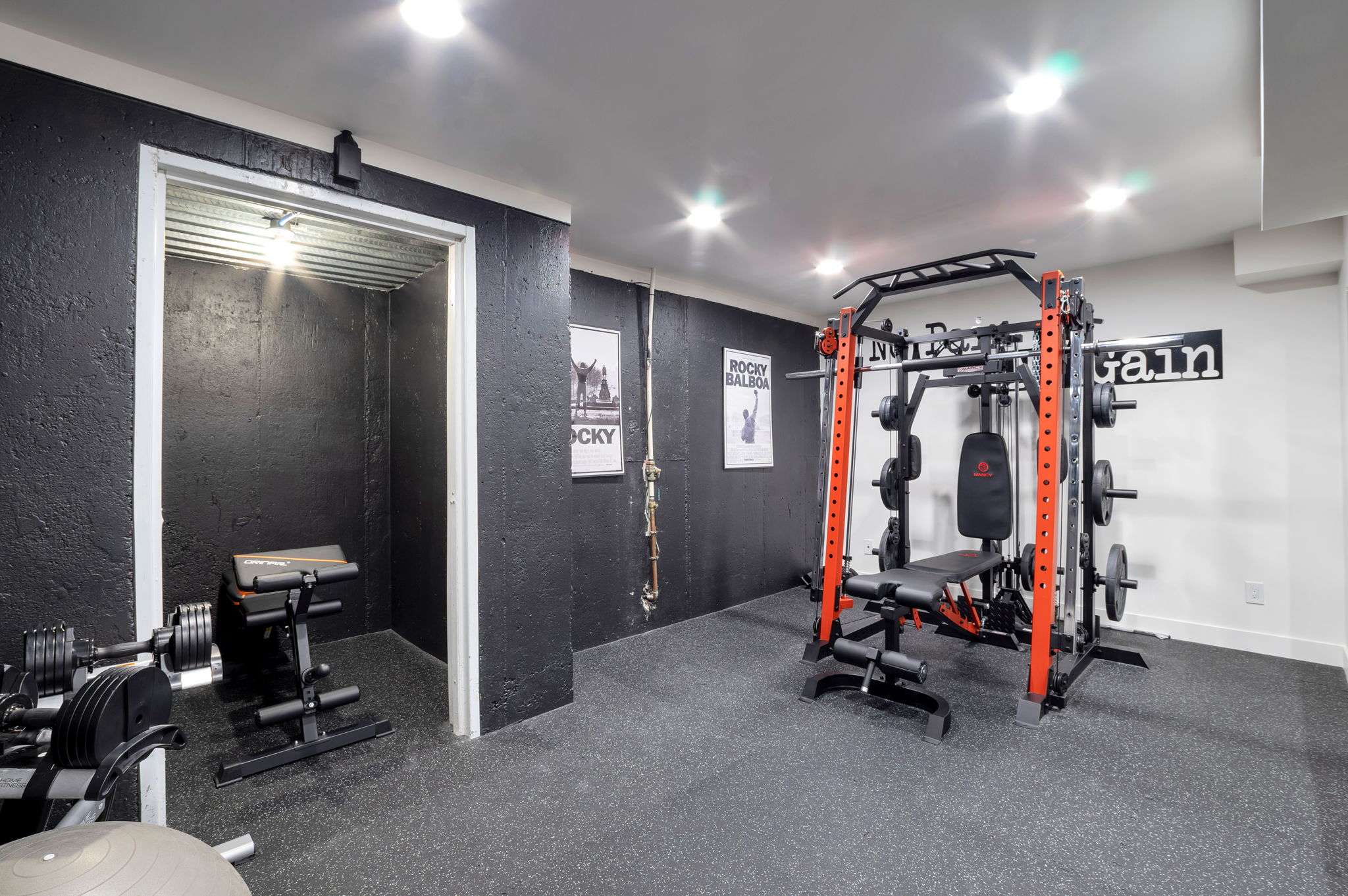 Purpose-built exercise room finished with rubber flooring and space for multiple workout stations.